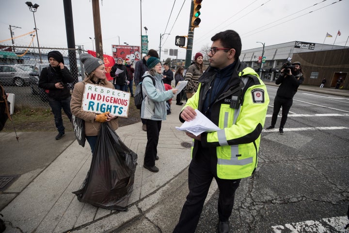 A Port Authority security guard hands out copies of an injunction to protesters in Vancouver, on Feb. 25, 2020. 