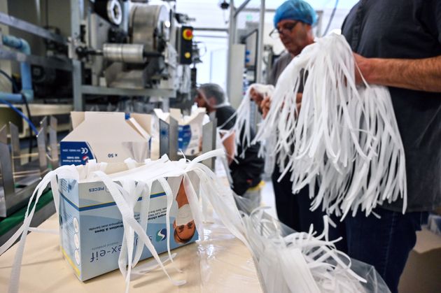 Des employés emballant des masques de protection respiratoire à l'usine du fabricant de...