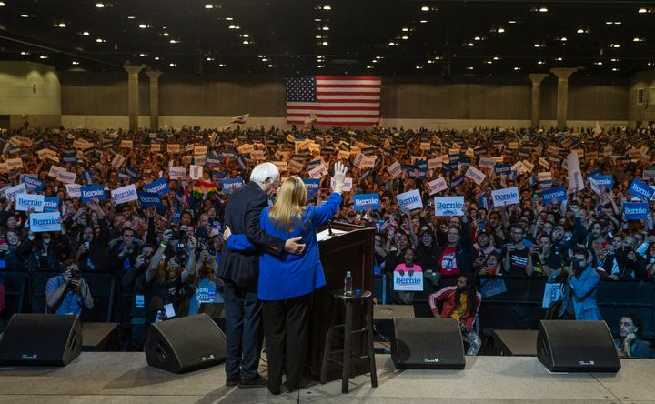 U.S. Sen. Bernie Sanders holds his wife, Jane, as they wave at supporters in Los Angeles on March 1. A sweeping victory in California would give Sanders a massive advantage that will be hard for his rivals to match.