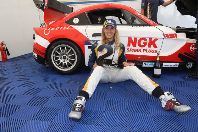 Charlie Martin poses with prize in front of car.