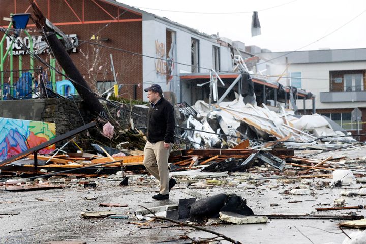 A man walks past storm debris following a deadly tornado Tuesday in Nashville, Tenn.