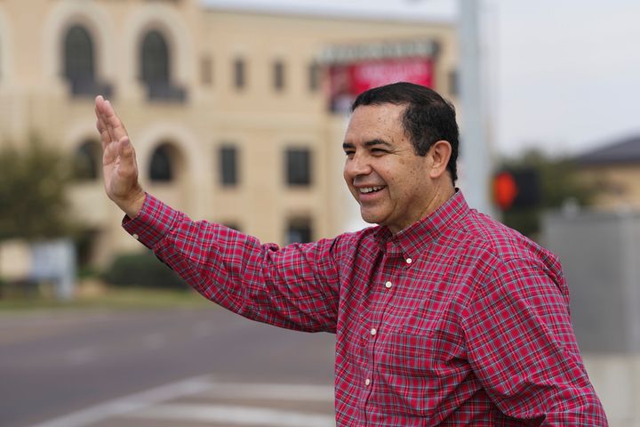 Rep. Henry Cuellar waves to voters driving past on Monday in Laredo, Texas. He had reason again to smile on Tuesday night.