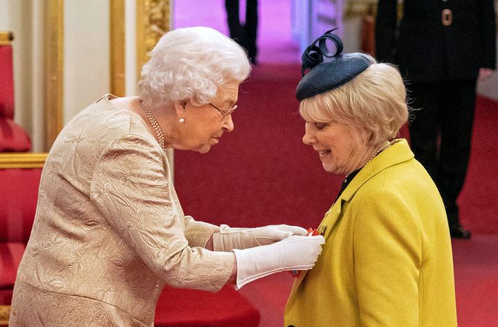 Queen Elizabeth II wore gloves as she awarded honors during an investiture ceremony at Buckingham Palace in London on Tuesday.