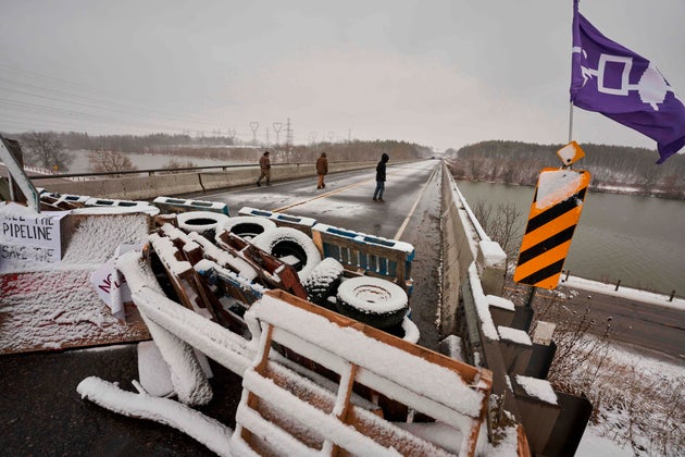 First Nations protesters walk on a bridge past their barricade on Highway 6 near Caledonia, Ont., which...