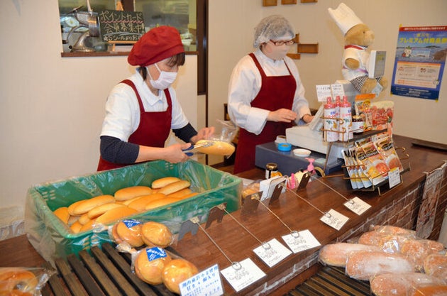 できあがったばかりの「コッペパン」を袋詰めにする店員=2020年3月4日、神奈川県藤沢市高倉、秦忠弘撮影