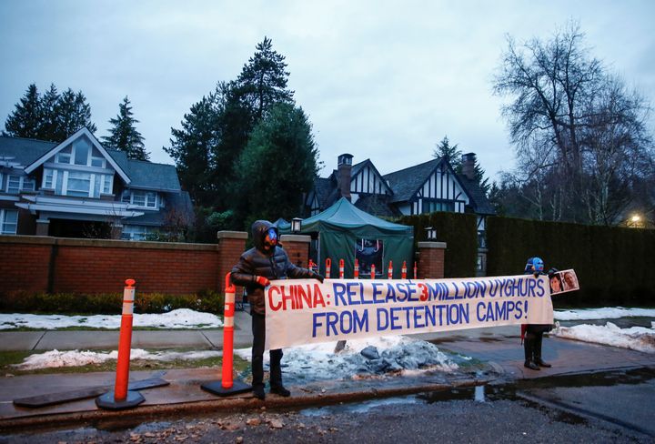 Protesters hold a large sign against China's Uighur camps, labeled as vocational training centres by the Chinese government, outside the home of Huawei Chief Financial Officer Meng Wanzhou before her extradition hearing at B.C. Supreme Court in Vancouver, British Columbia, Canada January 20, 2020. 