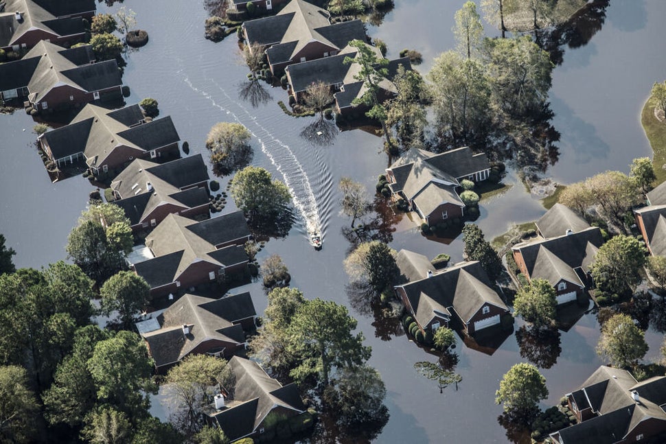 A boat makes it way past flooded property after Hurricane Florence past through Wallace, in North Carolina on Friday, Se