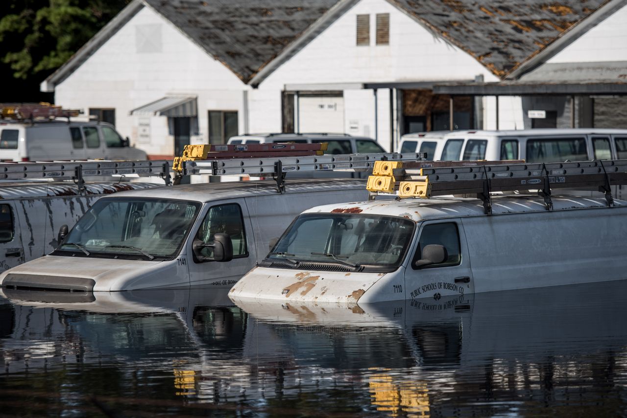 Vehicles are submerged vehicles at a Robeson County school parking lot on Oct. 12, 2016, in Lumberton, North Carolina.