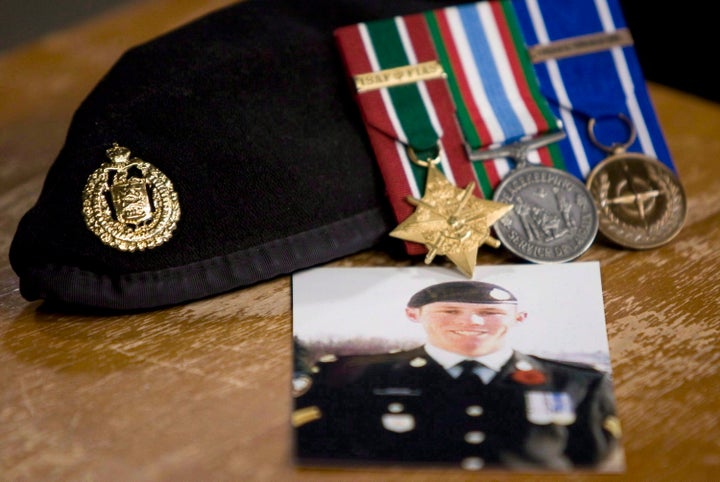 A photo of Cpl. Stuart Langridge is seen along with his beret and medals at a news conference on Parliament Hill on Oct. 28, 2010.