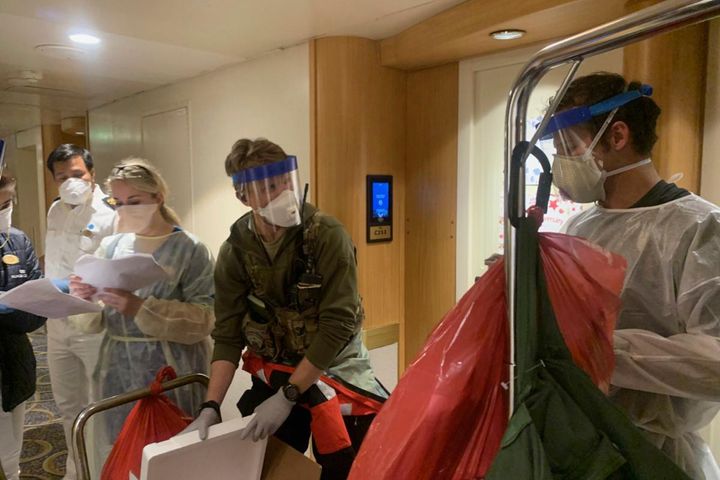 In this Thursday, March 5, 2020, photo, released by the California National Guard, Guardian Angels, a group of medical personnel with the 129th Rescue Wing, working alongside individuals from the Centers for Disease Control and Prevention, don protective equipment after delivering virus testing kits to the Grand Princess cruise ship off the coast of California.