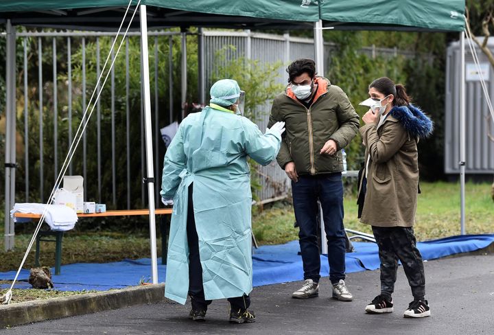 A medical worker wearing protective mask speaks to people at a medical checkpoint at the entrance of the Spedali Civili hospital in Brescia, Italy March 3, 2020. REUTERS/Flavio Lo Scalzo