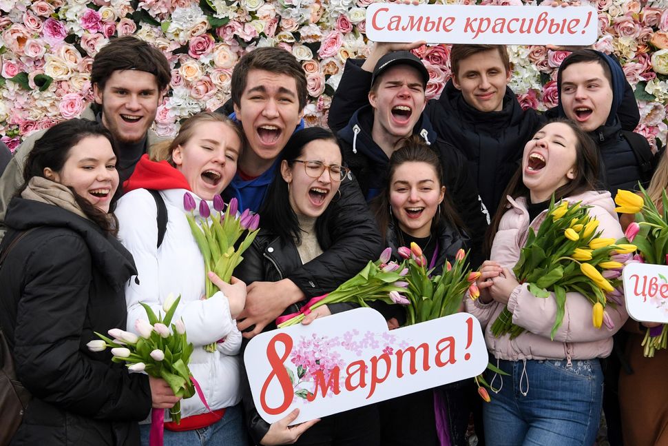 Participants react on the finish line of a 400m running event held on the International Women's day in Moscow, during which hundreds of me run with a tulip and gift it to women on the finishing line. 