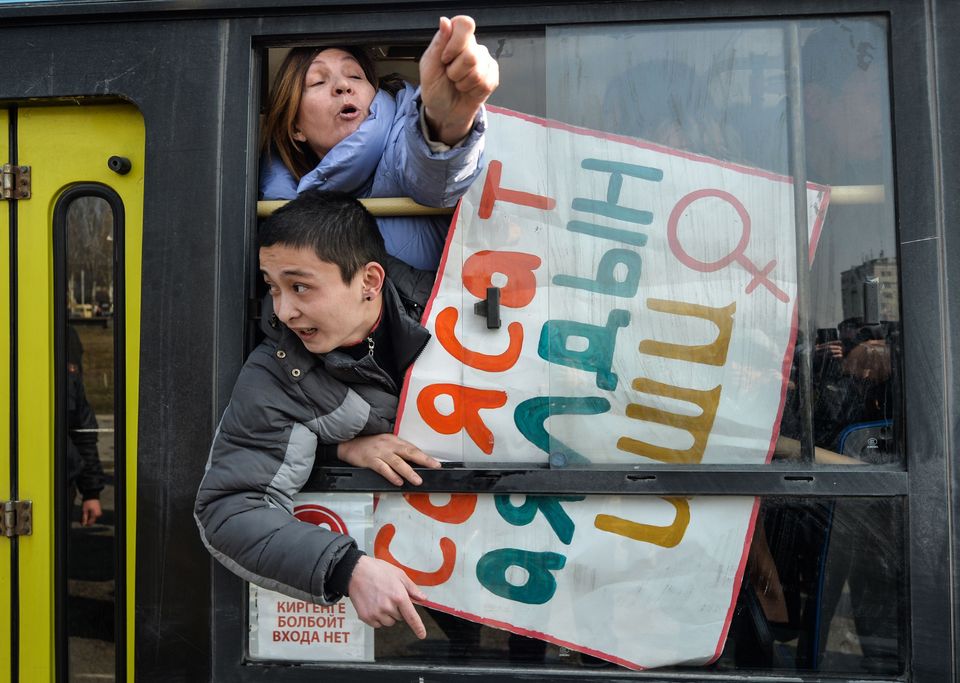 Women gesture from a police van after they were arrested while protesting against gender-based violence to mark International Women's Day in Bishkek, Kyrgyzstan. The detentions came after the men wearing face masks and pointed national hats attacked the crowd, tearing up their posters, popping balloons with toy pistols and throwing eggs at the women before fleeing the scene. 