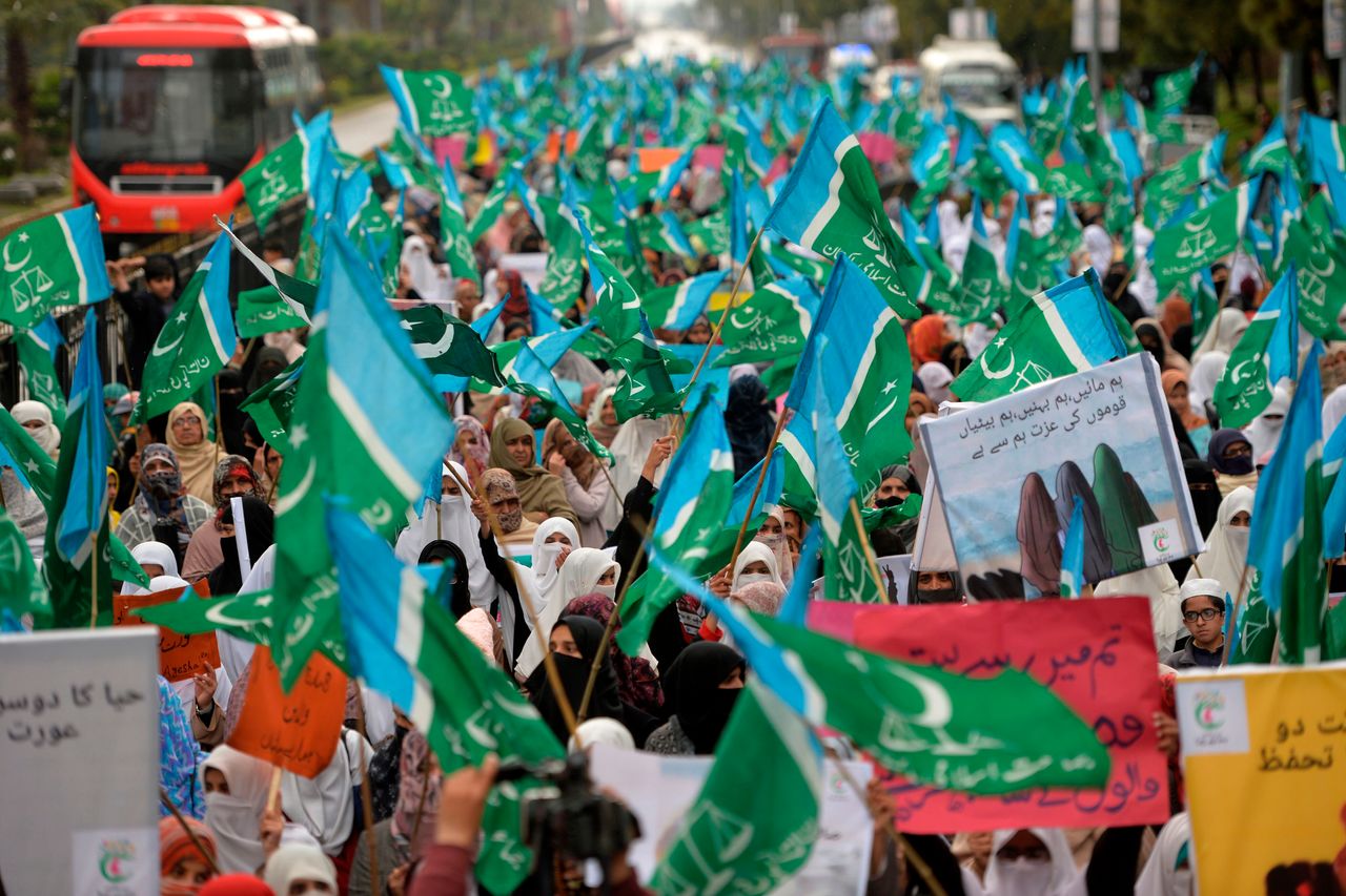 Veiled female supporters of Pakistani Islamic political party Jamaat-e-Islami (JI) carry placards and banners as they march during a rally to mark the International Women's Day in Islamabad.