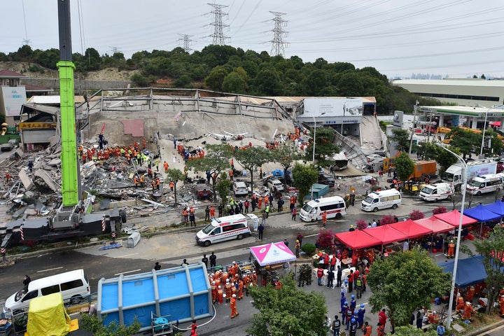 In this photo released by Xinhua News Agency, rescuers search for victims at the site of a hotel collapse in Quanzhou, southe