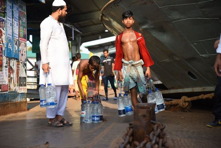 乗船客に飲料水を売りにでかける少年（バングラデシュ）