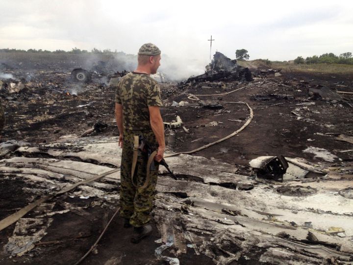 An armed pro-Russian separatist stands at a site of a Malaysia Airlines Boeing 777 plane crash in the settlement of Grabovo in the Donetsk region, July 17, 2014