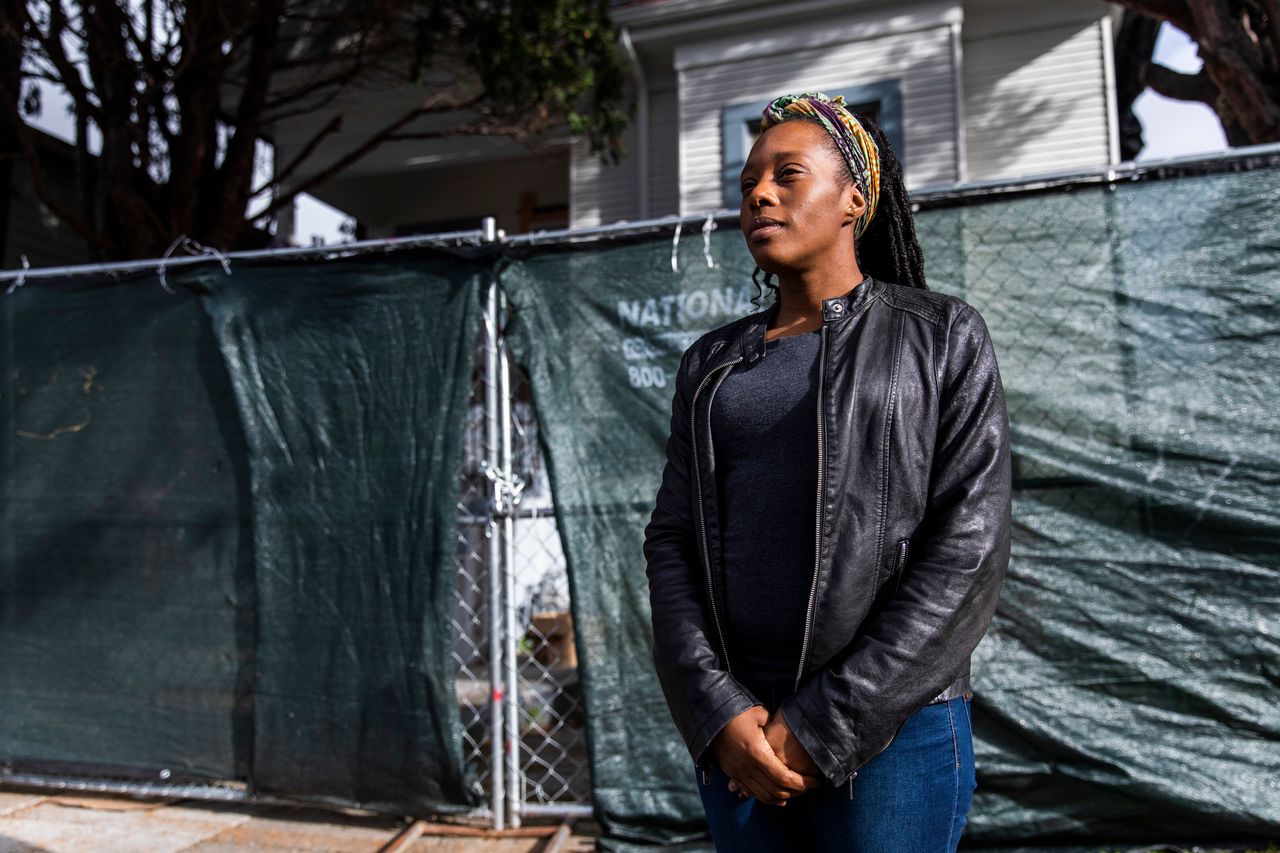 Moms 4 Housing activist Dominique Walker in front of the now fenced-off vacant home that she and other homeless or insecurely housed mothers occupied during a monthslong protest which ended in a court-ordered eviction, in Oakland, California.