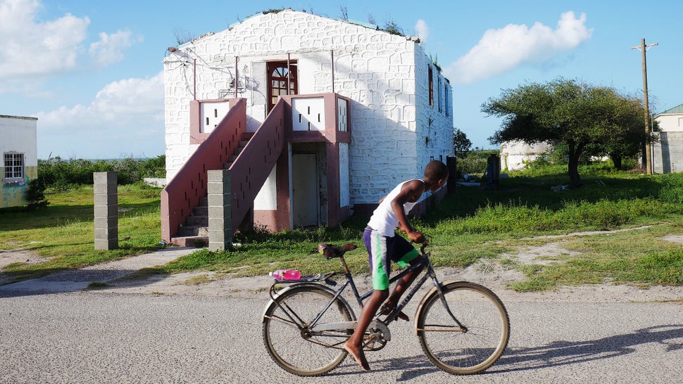A young boy rides his bicycle past the damaged Barbuda Council Hall in the village of Codrington. Hurricane Irma destroyed 95