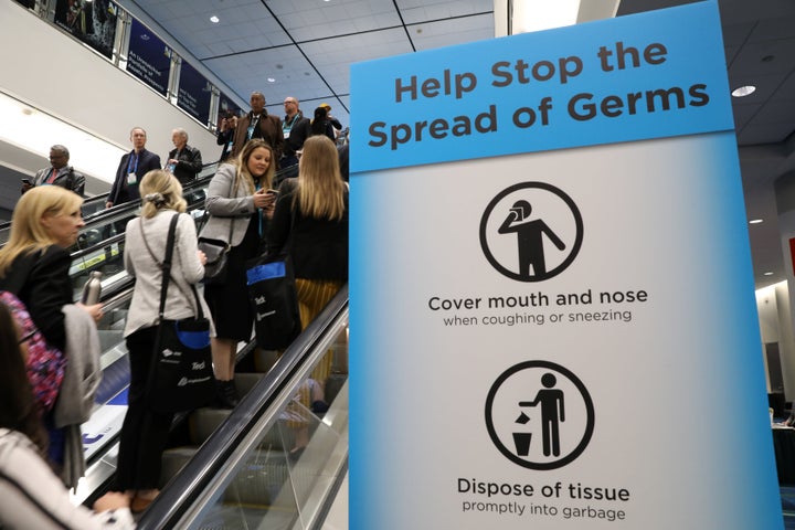 Visitors pass a sign warning about the spread of germs in Toronto on March 1, 2020. 