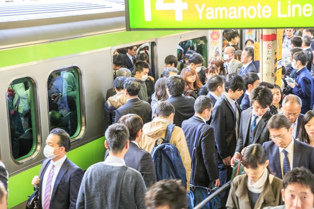 通勤時、満員電車に乗り込む人々