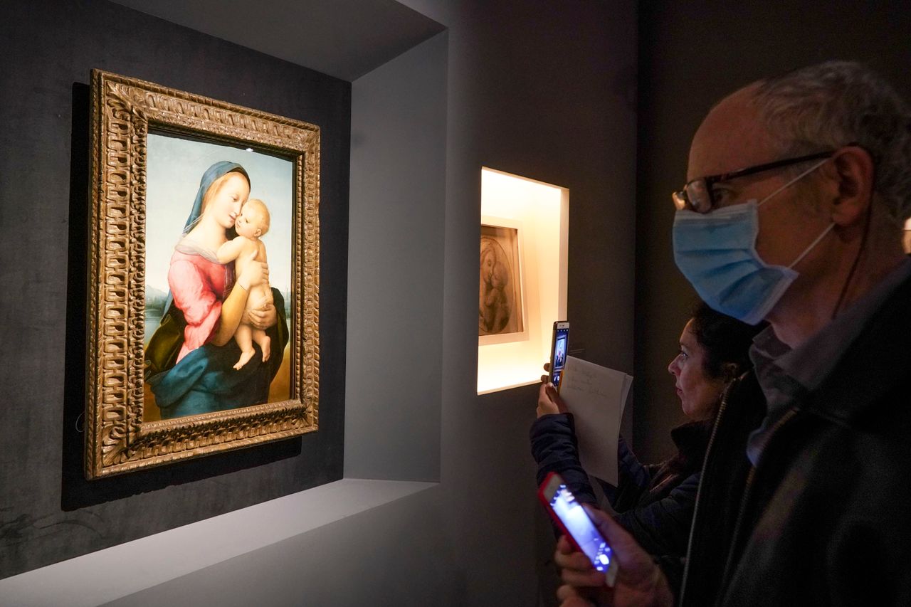 Άνδρας (που φορά χειρουργική μάσκα) θαυμάζει το έργο «Madonna Tempi» (1508). 