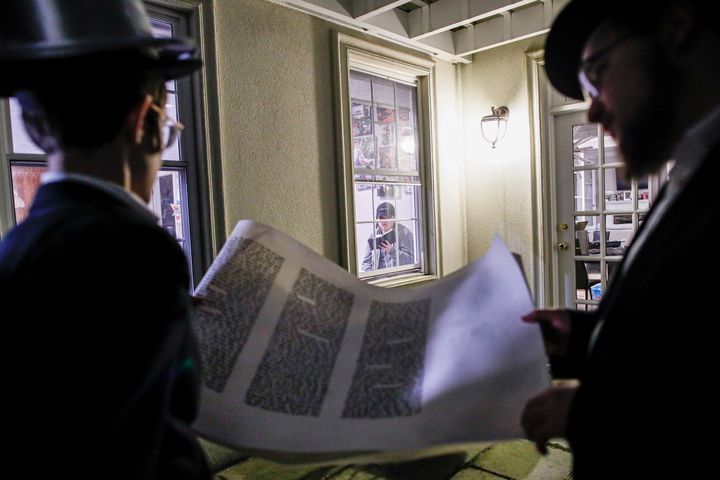 Student volunteers perform a Purim reading from the Book of Esther for residents under self-quarantine due to potential exposure to the new coronavirus, Monday, March 9, 2020, in New Rochelle, N.Y. (AP Photo/John Minchillo)