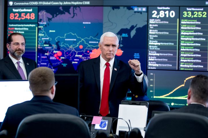 A large monitor displaying a map of Asia and a tally of total coronavirus cases, deaths, and recovered, is visible behind Vice President Mike Pence, center, and Health and Human Services Secretary Alex Azar, left, as they tour the Secretary's Operations Center following a coronavirus task force meeting at the Department of Health and Human Services, Thursday, Feb. 27, 2020, in Washington. (AP Photo/Andrew Harnik)