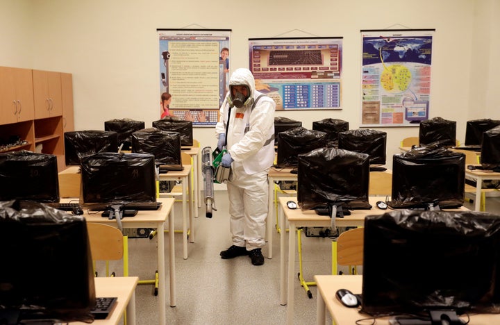 A worker in a protective suit disinfects a classroom inside of an elementary school due to coronavirus concerns in Prague, Czech Republic, March 10, 2020. REUTERS/David W Cerny