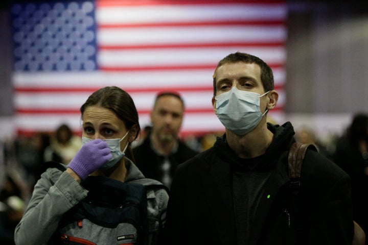 Alaina Marasa (left) and Tobias Riker of La Mirada, California, wear face masks and gloves at a Los Angeles campaign event for Democratic presidential candidate Sen. Bernie Sanders (I-Vt.) on Sunday.