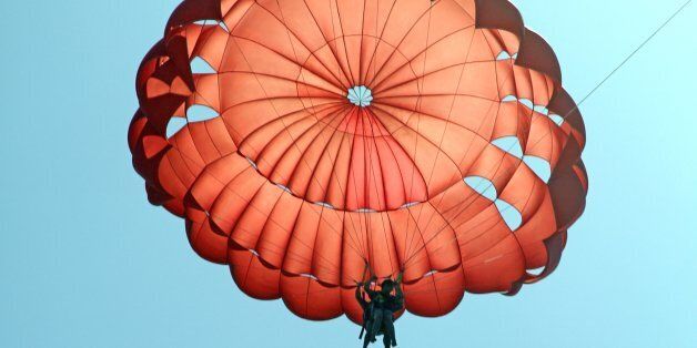 man jumping with parachute over ...