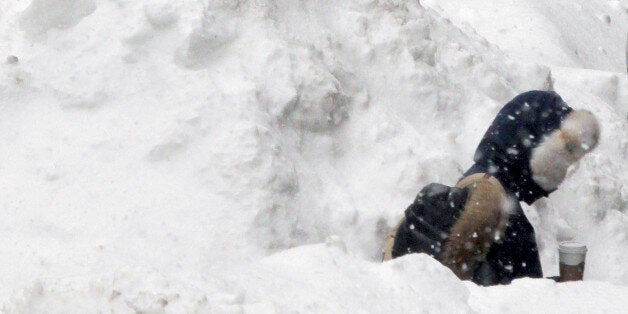 Commuters walk between piles of snow on a street in downtown Boston, Wednesday, Feb. 11, 2015. The National Weather Service forecasts a weak weather system may bring 2 to 4 inches of new snow Thursday into Friday morning to the region, which already has seen record snowfalls this winter. (AP Photo/Bill Sikes)