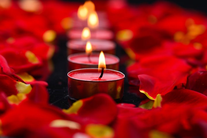 red candles with rose petals in ...