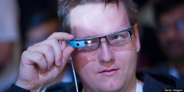 An attendee adjusts his Google Project Glass glasses during the Google I/O Annual Developers Conference in San Francisco, California, U.S., on Wednesday, May 15, 2013. Google Inc. introduced a subscription music-streaming service, one of several product updates to be unveiled at a developer meeting this week as the search provider seeks to attract more users and advertisers. Photographer: David Paul Morris/Bloomberg via Getty Images
