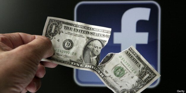 GERMANY - MAY 23: Torn dollar bill in front of the Facebook logo, symbol picture: 'The downward trend continues' - big losses for investors of Facebook shares. (Photo by Ulrich Baumgarten via Getty Images)