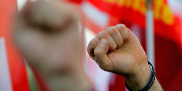 PARIS - OCTOBER 12: Protestors raise their fists on October 12, 2010 in Paris, France. French unions have staged a national day of strikes over the government's pension reforms. President Nicolas Sarkozy is attempting to bring in reforms that will see the minimum age of retirement raised from 65 to 67 years of age as he attempts to manage the country's deficit. (Photo by Franck Prevel/Getty Image)