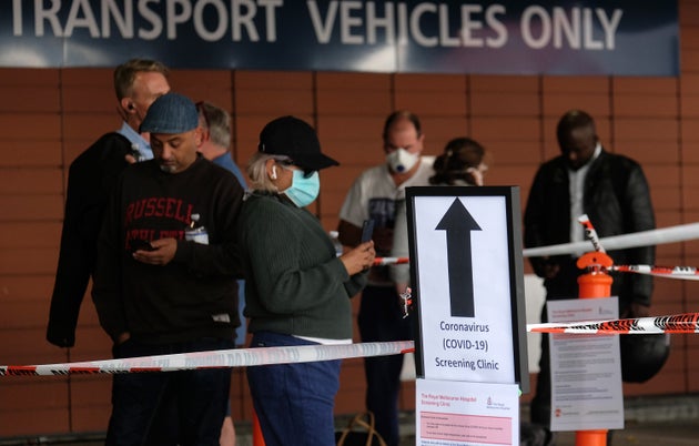 People line up for COVID-19 screening outside the Royal Melbourne Hospital on March 11 in Melbourne, Australia.