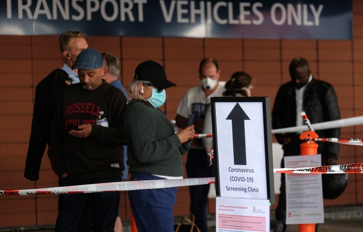 People line up for COVID-19 screening outside the Royal Melbourne Hospital on March 11 in Melbourne, Australia.