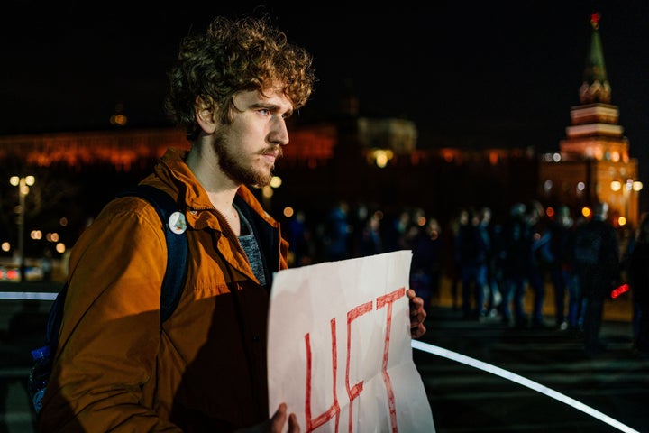 A man holding a placard reading "No" demonstrates against resetting the term count in front of a monument to Vladimir the Gre