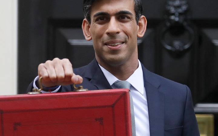 Chancellor Rishi Sunak stands outside No 11 Downing Street and holds up the traditional red box that contains the Budget speech.