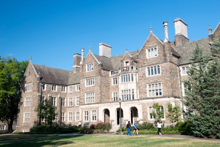 Three students walk past a dorm building on the campus of Duke University on Aug. 11, 2017.