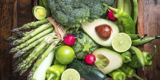Mix of fresh green vegetables on rustic wood background.Peppers,cabbage,celery,avocado,asparagus,cucumber,radishes, broccoli, limes, beans, peas,leek.Veg food concept.