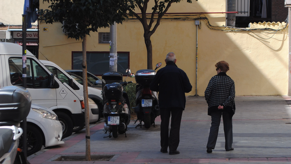 Leonor e Antonio, de 85 e 88 anos respectivamente, descem para a rua para levar o lixo para fora.