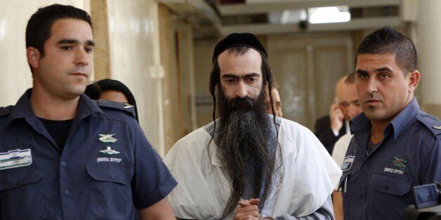 Israeli ultra-orthodox Yishai Shlissel (C), suspected of stabbing six Gay Pride marchers the previous day, is brought handcuffed to the Jerusalem Magistrate's Court on July 31, 2015. Shlissel was released from jail three weeks ago after completing a 10-year sentence for a similar attack in 2005. Police said the suspect's detention was extended for 12 days while investigations continue into July 30 night's attack. AFP PHOTO / GALI TIBBON (Photo credit should read GALI TIBBON/AFP/Getty Images)