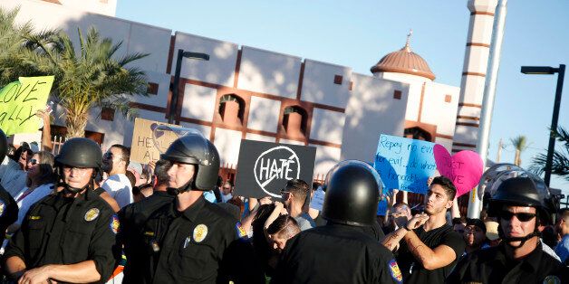 Protesters gather outside the Islamic Community Center of Phoenix, Friday, May 29, 2015. About 500 protesters gathered outside the Phoenix mosque on Friday as police kept two groups sparring about Islam far apart from each other. (AP Photo/Rick Scuteri)