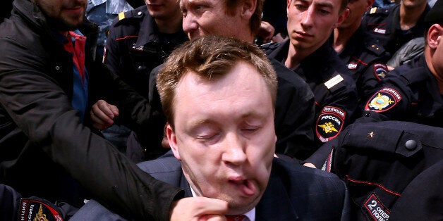 Unknown anti-gay activist hits Russia's gay and LGBT rights activist Nikolai Alexeyev (C) during unauthorized gay rights activists rally in cental Moscow on May 25, 2013. Moscow city authorities on May 15 turned down demands for a gay rights rally, but Alexeyev said he would fight a ban in court. AFP PHOTO/ANDREY SVITAILO (Photo credit should read ANDREY SVITAILO/AFP/Getty Images)