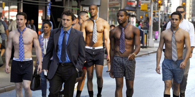 Male models in the underwear follow men in suits around Times Square June 27, 2012 to promote the Men's Wearhouse national suit drive starting June 27?July 31. This is the fifth year the company has hosted the drive to encourage people to donate their unwanted business attire to millions who otherwise couldn't afford it and are trying to re-enter the workforce. The drive collects both men's and women's suits, shirts, jackets, belts and shoes and will distribute them to local charities. AFP PHOTO TIMOTHY A. CLARY (Photo credit should read TIMOTHY A. CLARY/AFP/GettyImages)