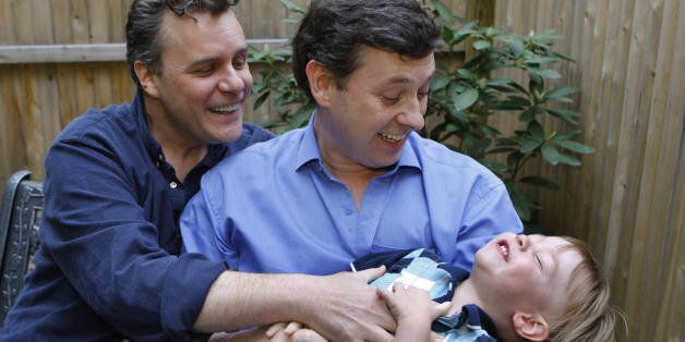 Gay couple Jeffrey Parsons (R) and Chris Hietikko pose with their son Henry Hietikko-Parsons in the garden of their house in New York on May 01, 2008. Henry was conceived by the couple via artificial insemination and a surrogate mother.Surrogates, who are paid about $20,000 above and beyond medical expenses to carry a child, are responsible for approximately 1,000 births a year, according to the Organization of Parents Through Surrogacy, that records births brokered through agencies and privately over the Internet. AFP PHOTO/Emmanuel Dunand (Photo credit should read EMMANUEL DUNAND/AFP/Getty Images)