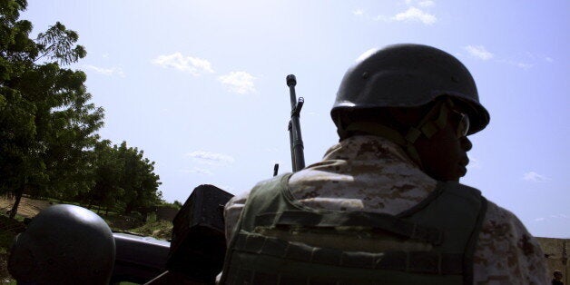 A soldier from Niger escorts U.S. soldiers back to their base following an anti-Boko Haram summit in Diffa city, Niger September 3, 2015. Picture taken September 3, 2015. To match Exclusive USA-NIGER/BOKO HARAM REUTERS/Warren Strobel