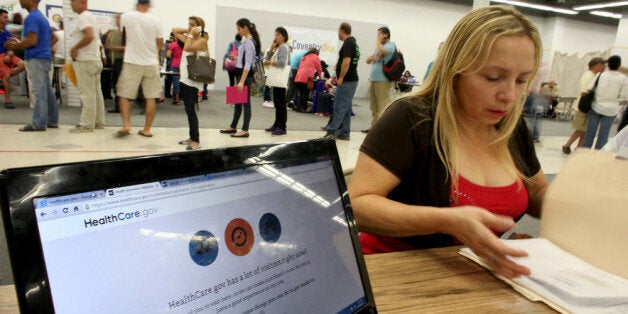 MIAMI, FL - MARCH 31: Norma Licciardello sits with an agent from Sunshine Life and Health Advisors as they wait for the Affordable Care Act website to come back on line as she tries to purchases a health insurance plan at a store setup in the Mall of Americas on March 31, 2014 in Miami, Florida. Today is the last day for the first yearly sign-up period and Sunshine Life and Health saw a wait of four hours or more for people to see a health insurance advisor. (Photo by Joe Raedle/Getty Images)